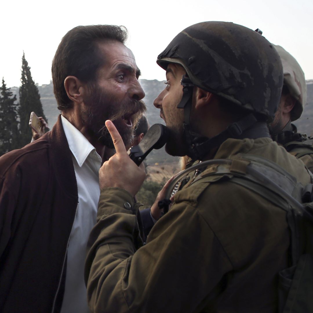 رجل فلسطيني بيجادل مع جندي إسرائيلي