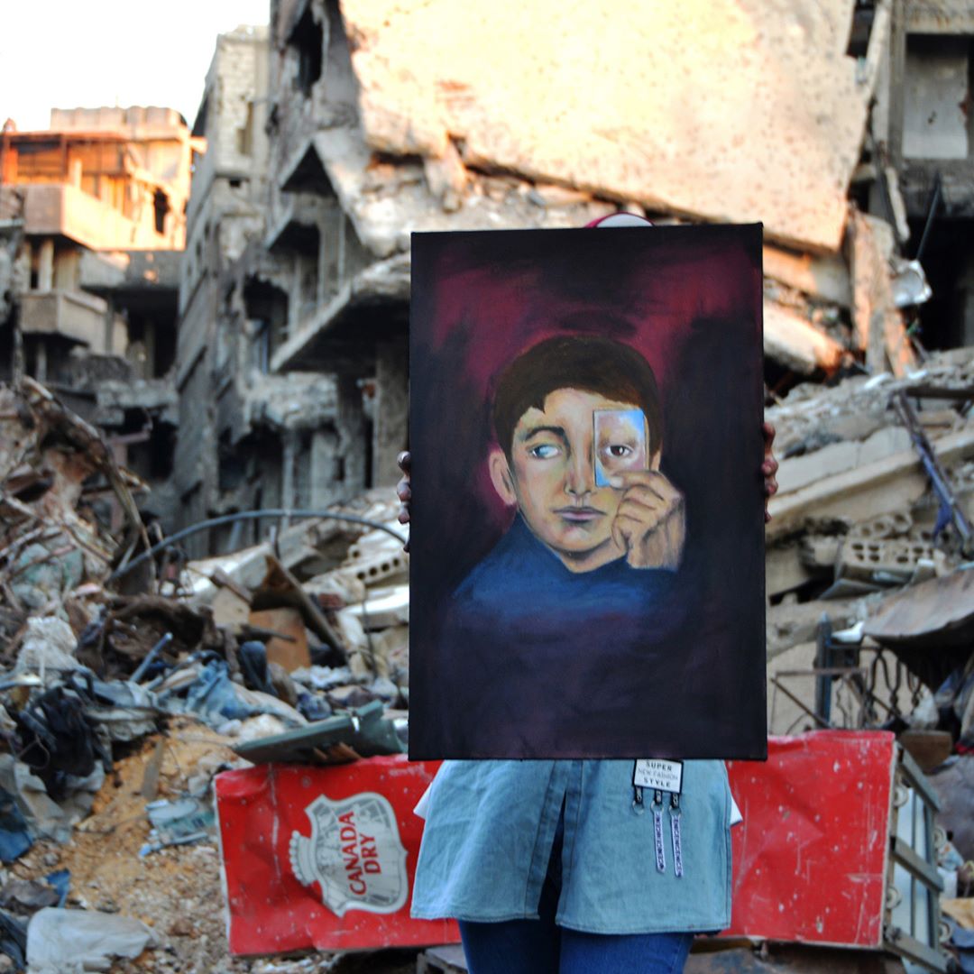 فنان شايل لوحة في مخيم اليرموك للاجئين